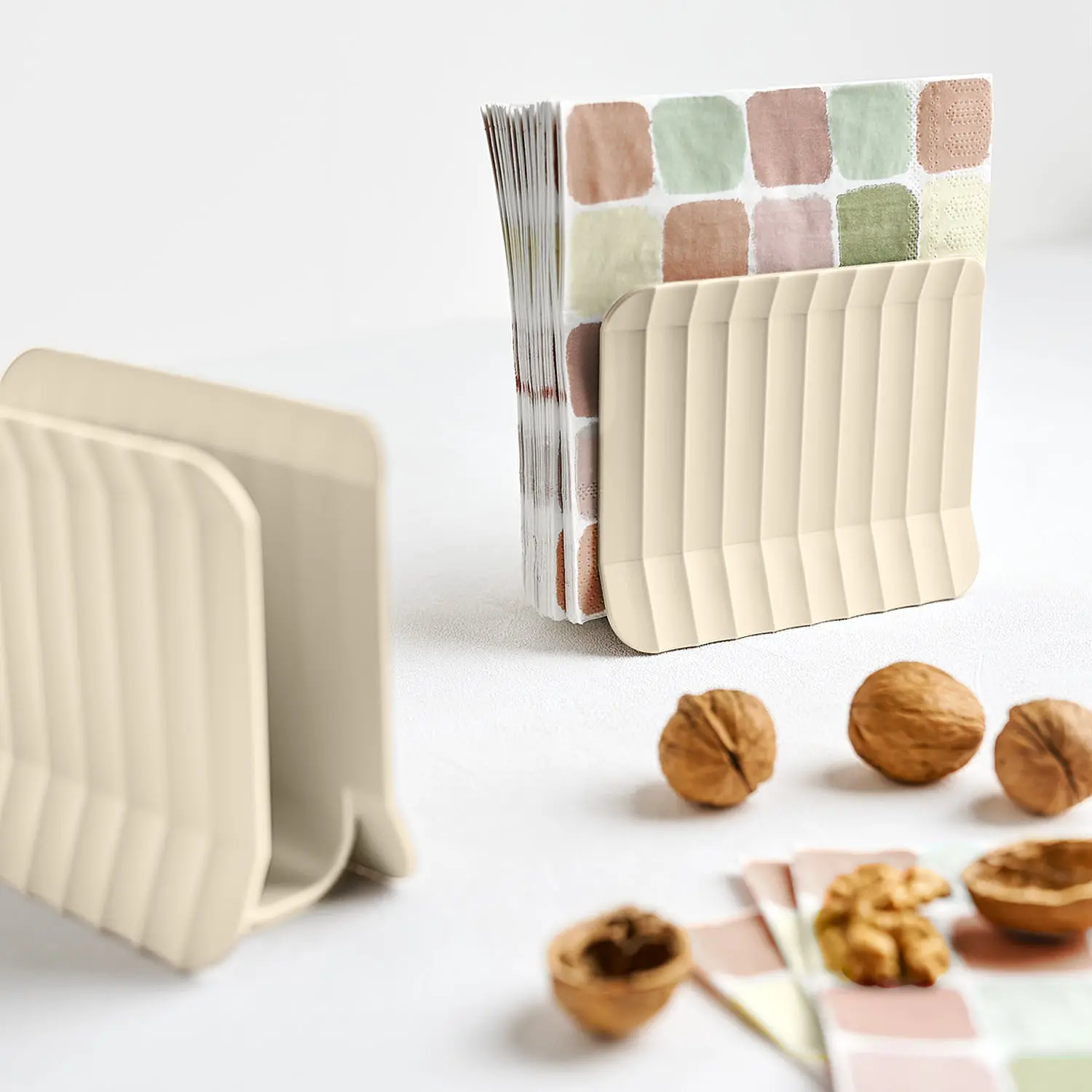 Arca Blim Plus: napkin holder in Brown Sugarcolor, with colorful fabrics and dried fruit on a light background