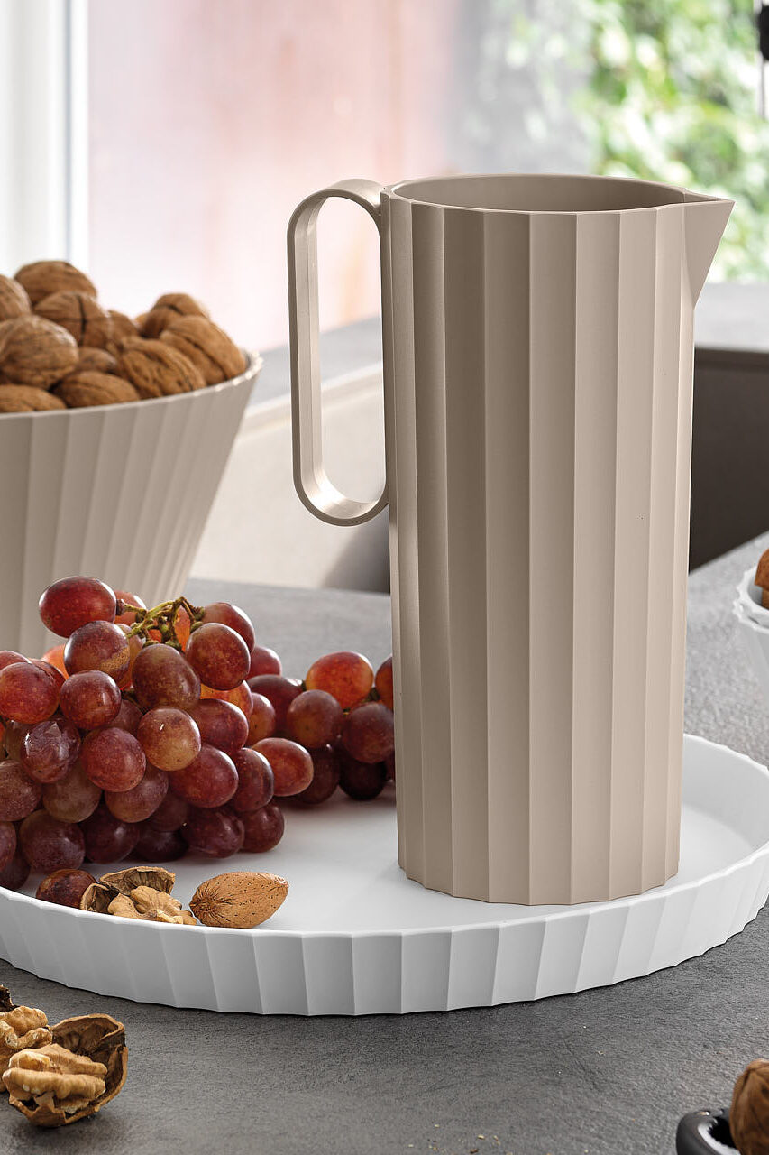 Blim Plus Paestum Hera, pitcher and bowls on a table with grapes and dried fruit.