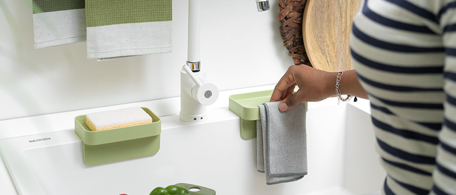 Blim Plus Battigia: accessori da cucina con spugna, vassoio e asciugamano su lavabo bianco