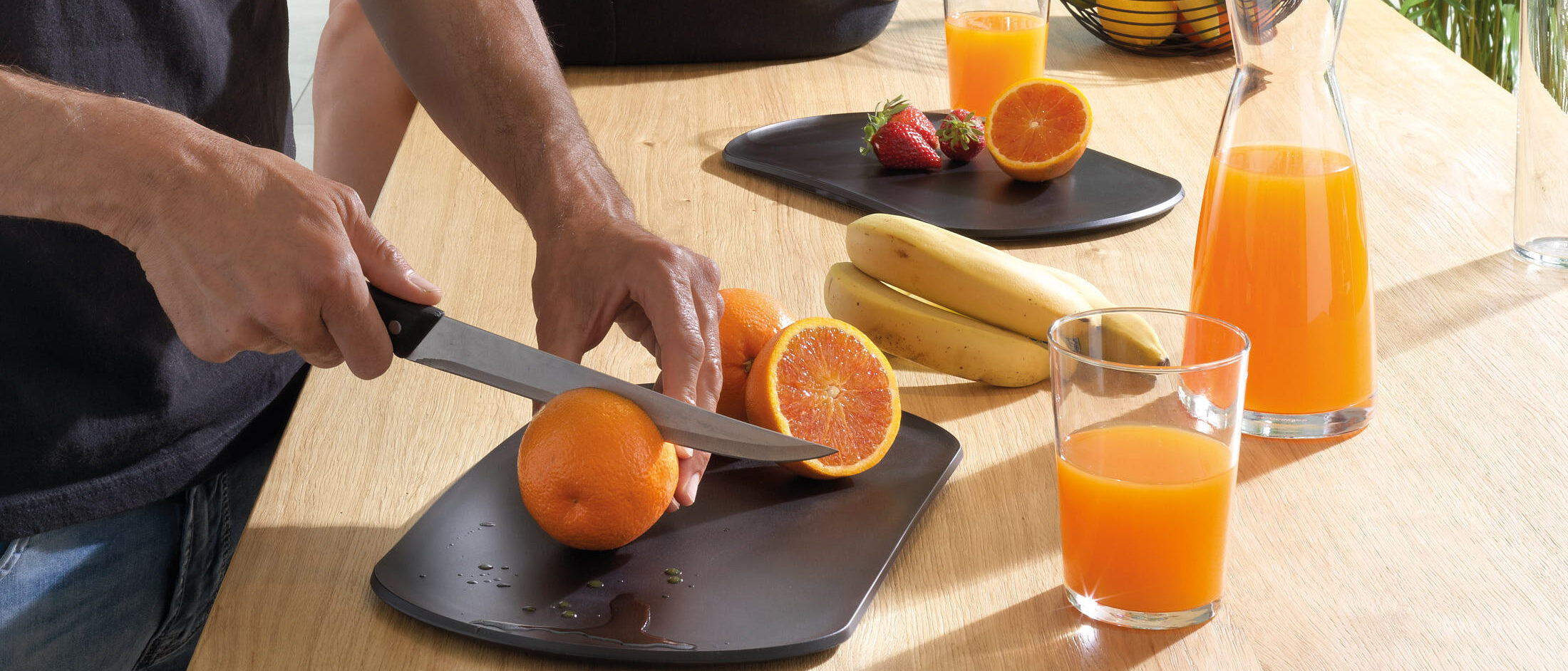 Skateboard Create di Blim Plus: taglio di arance su tagliere in colorazione Carbon Black